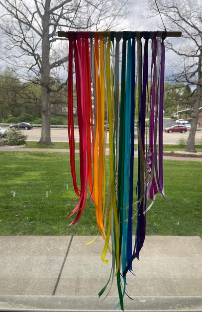 Rainbow fabric hanging from a pole outside