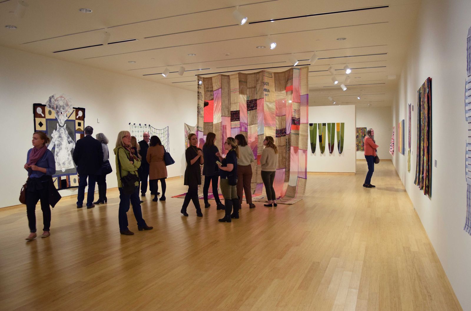 students looking at fabric hanging in gallery