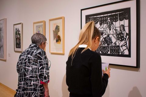 two visitors look at art on the gallery wall